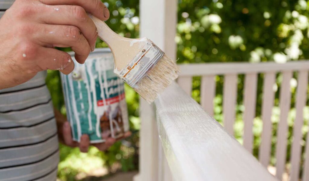 applying primer to wooden gazebo